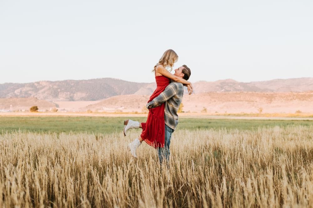 Engagement session couple kissing wildflower field Colorado