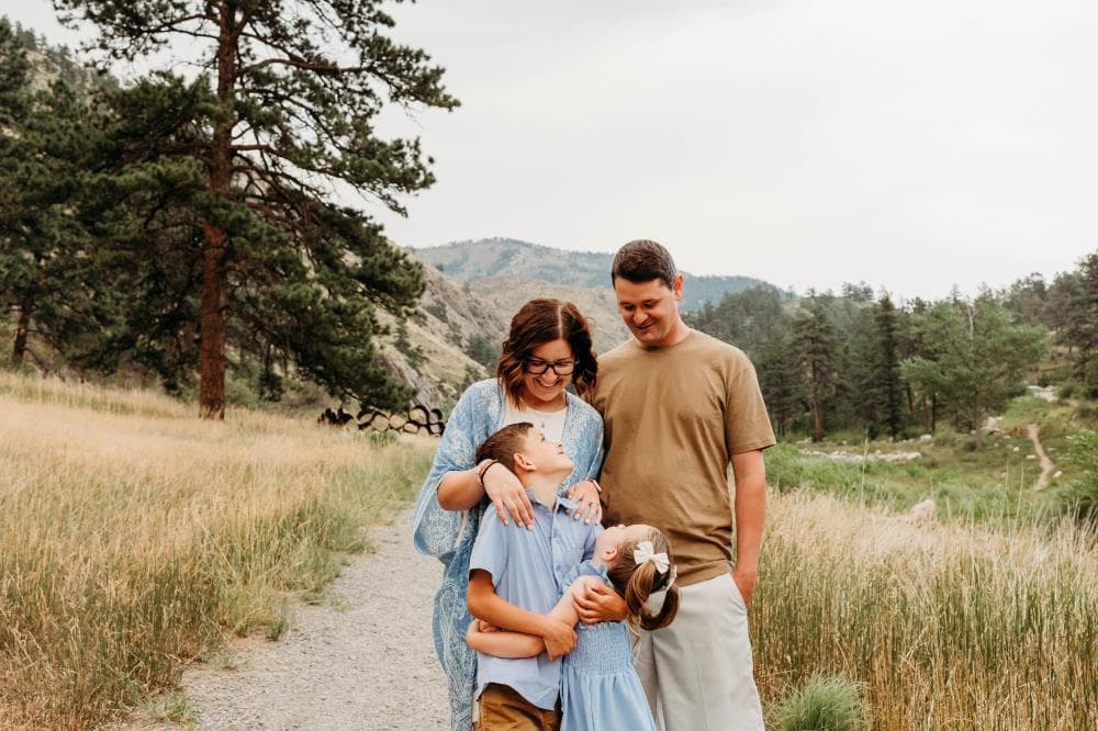 Family of four hugging outdoor portrait session Windsor Colorado