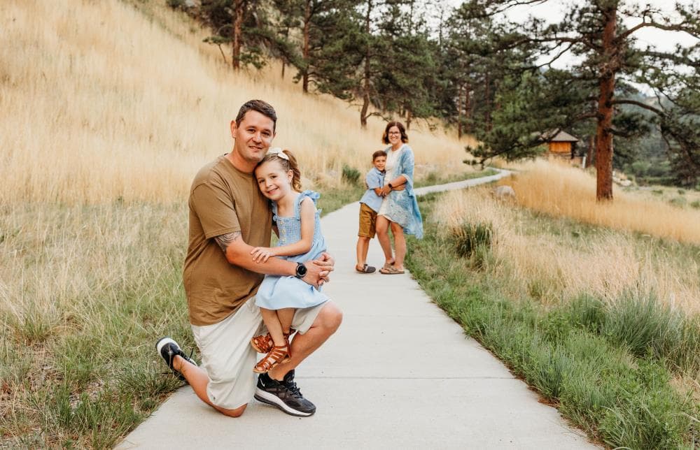 Family of four hugging outdoor portrait session Windsor Colorado