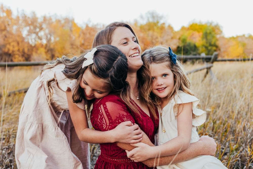 Family of four hugging outdoor portrait session Windsor Colorado