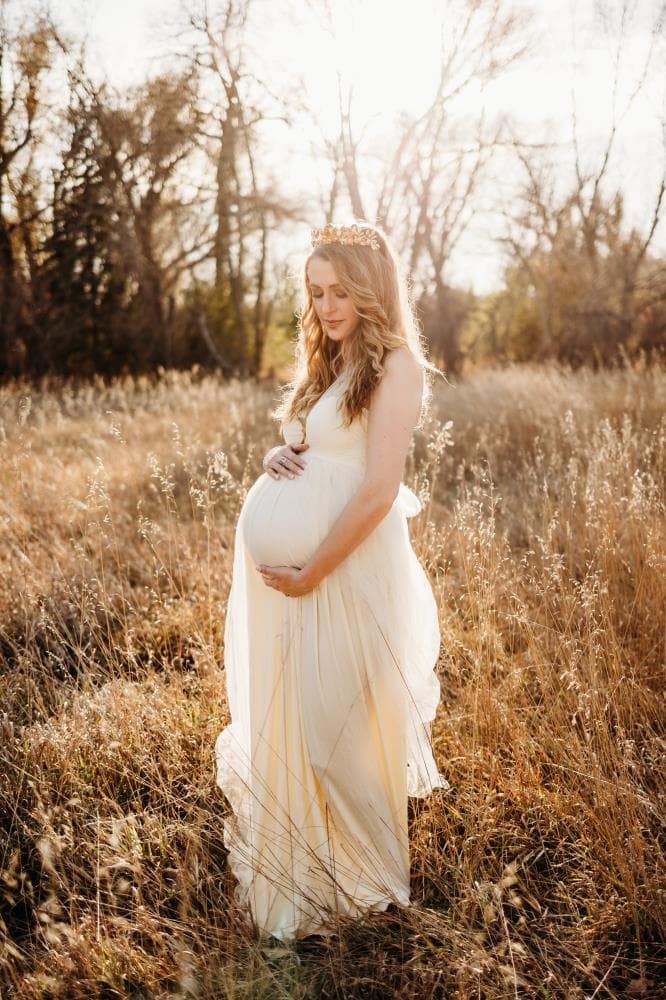 Pregnant mother cradling bump outdoor maternity session Northern Colorado
