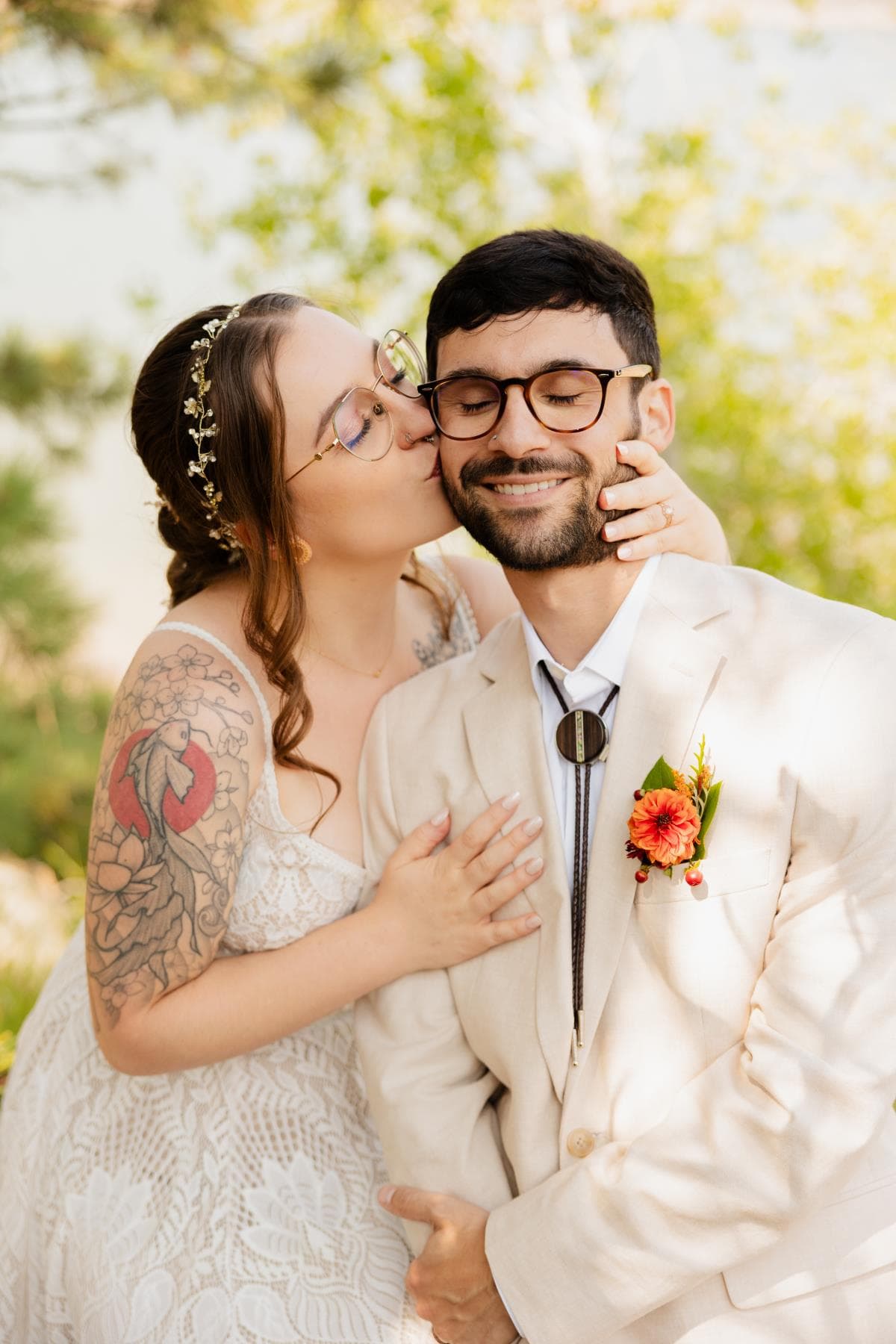 Bride and groom sharing first kiss at outdoor wedding ceremony Colorado