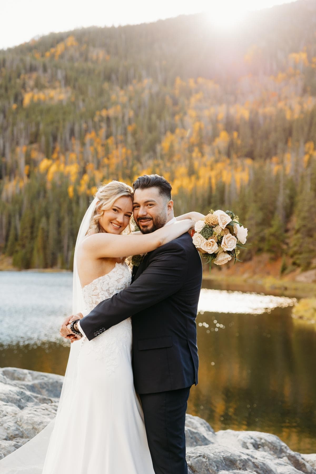 Bride and groom sharing first kiss at outdoor wedding ceremony Colorado