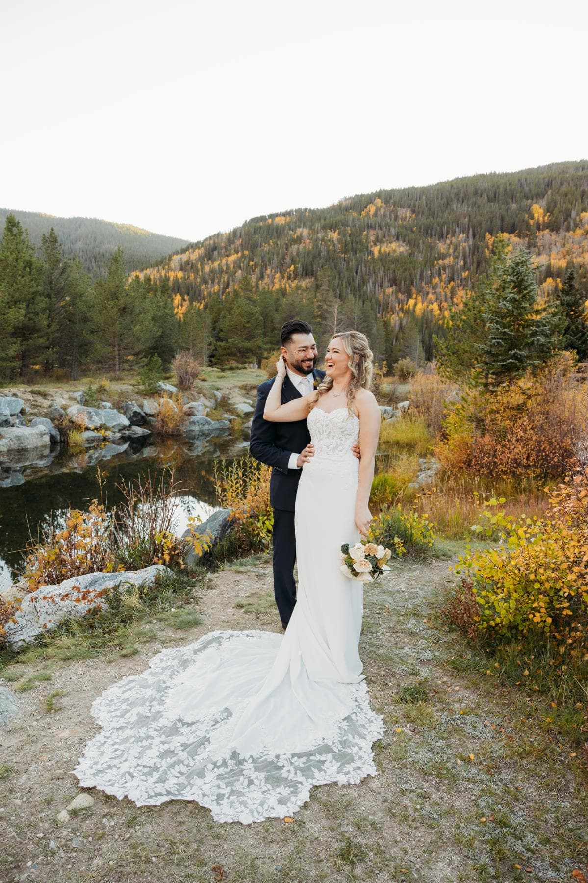 Bride and groom sharing first kiss at outdoor wedding ceremony Colorado