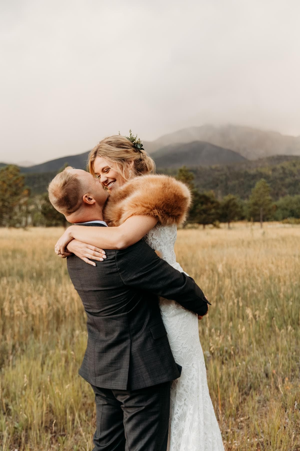 Bride and groom sharing first kiss at outdoor wedding ceremony Colorado