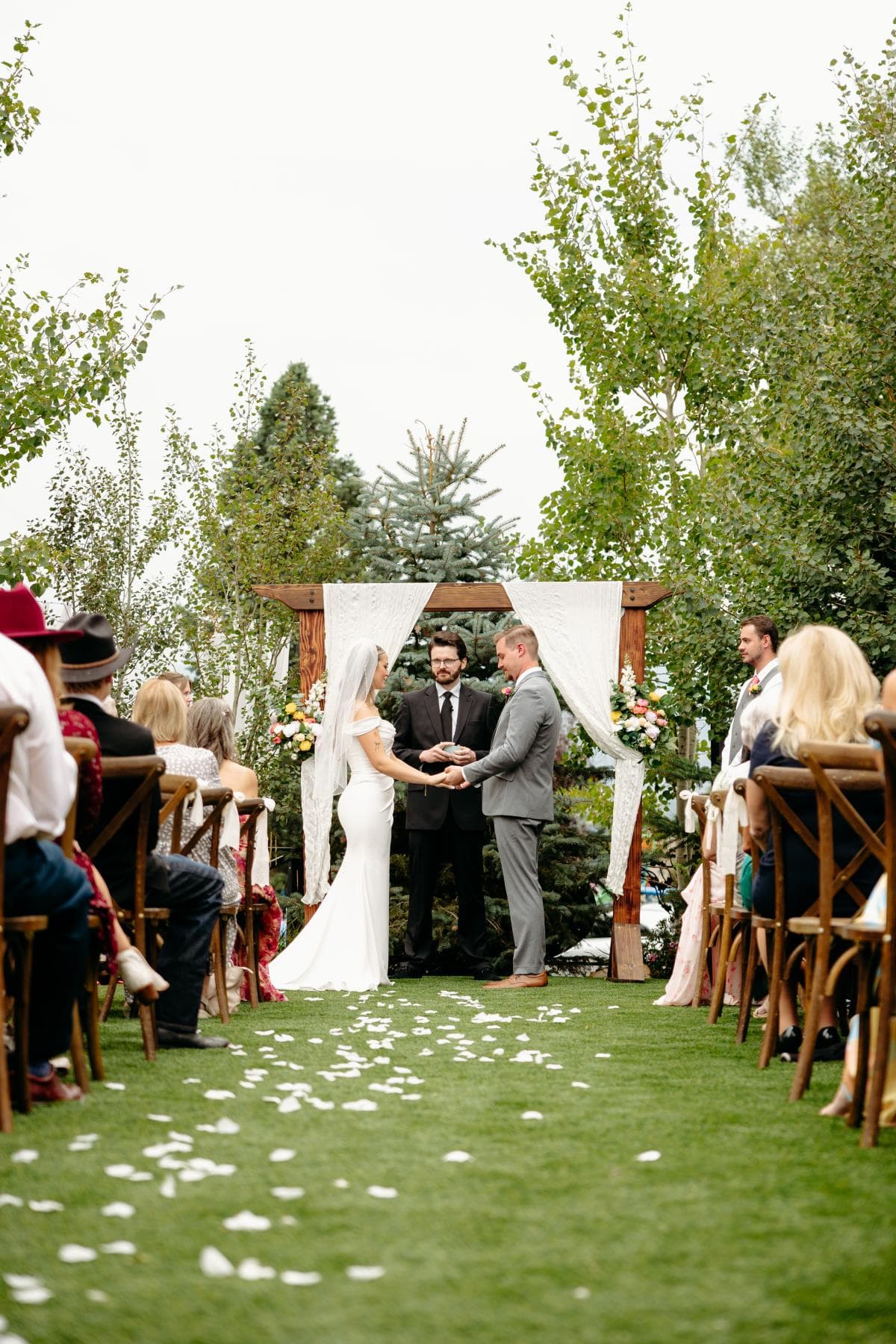 Bride and groom sharing first kiss at outdoor wedding ceremony Colorado