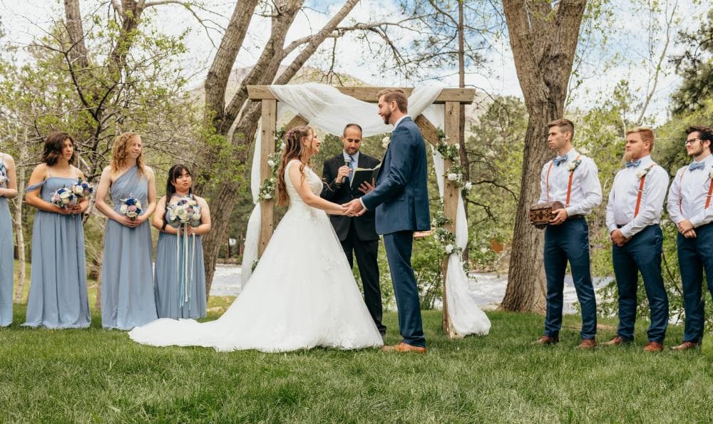 Bride and groom sharing first kiss at outdoor wedding ceremony Colorado
