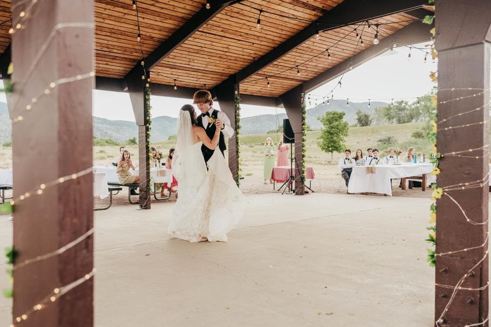 Bride and groom sharing first kiss at outdoor wedding ceremony Colorado