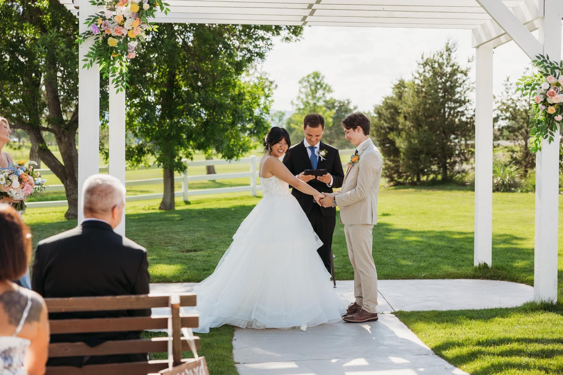 Bride and groom sharing first kiss at outdoor wedding ceremony Colorado